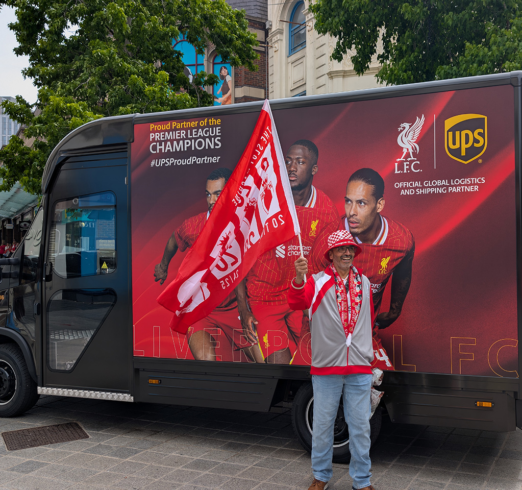 Soccer fan with flag in front of UPS truck