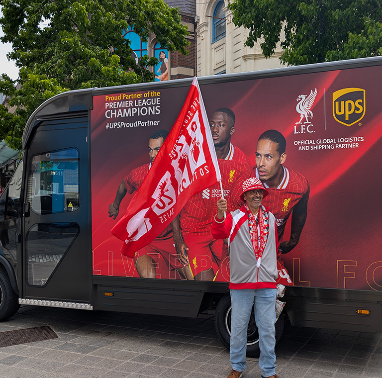 Soccer fan with flag in front of UPS truck