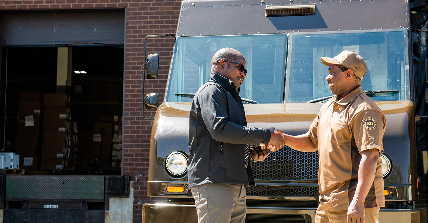 Man and  UPS driver shaking hands at loading dock