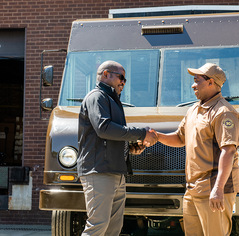 Man and  UPS driver shaking hands at loading dock