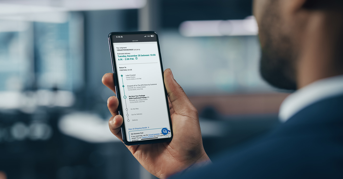 荷物追跡情報のある携帯電話を持っている男性