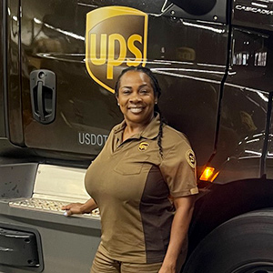 Membro do Círculo de Honra da UPS sorrindo orgulhosamente em frente à sua carreta