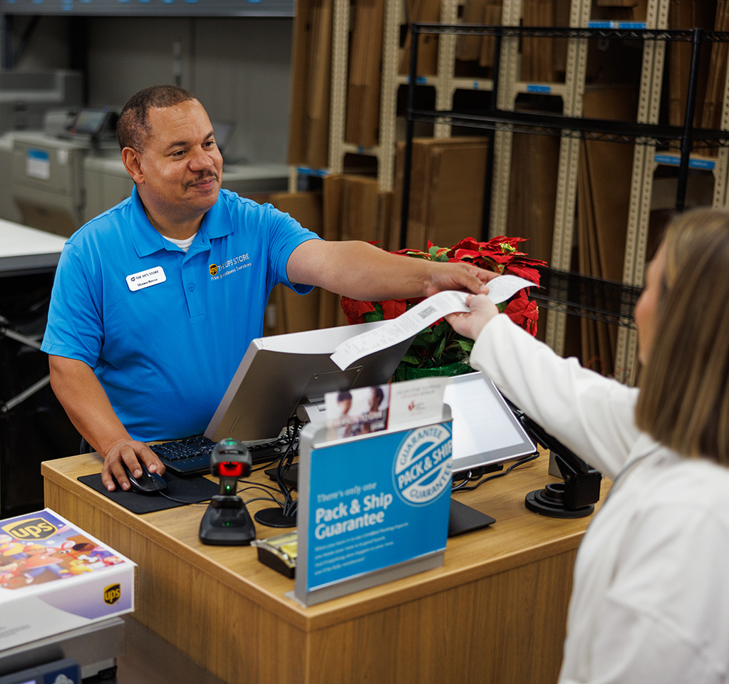 Een werknemer in The UPS Store die een klant helpt een doosvrije, etiketvrije retourzending te maken.