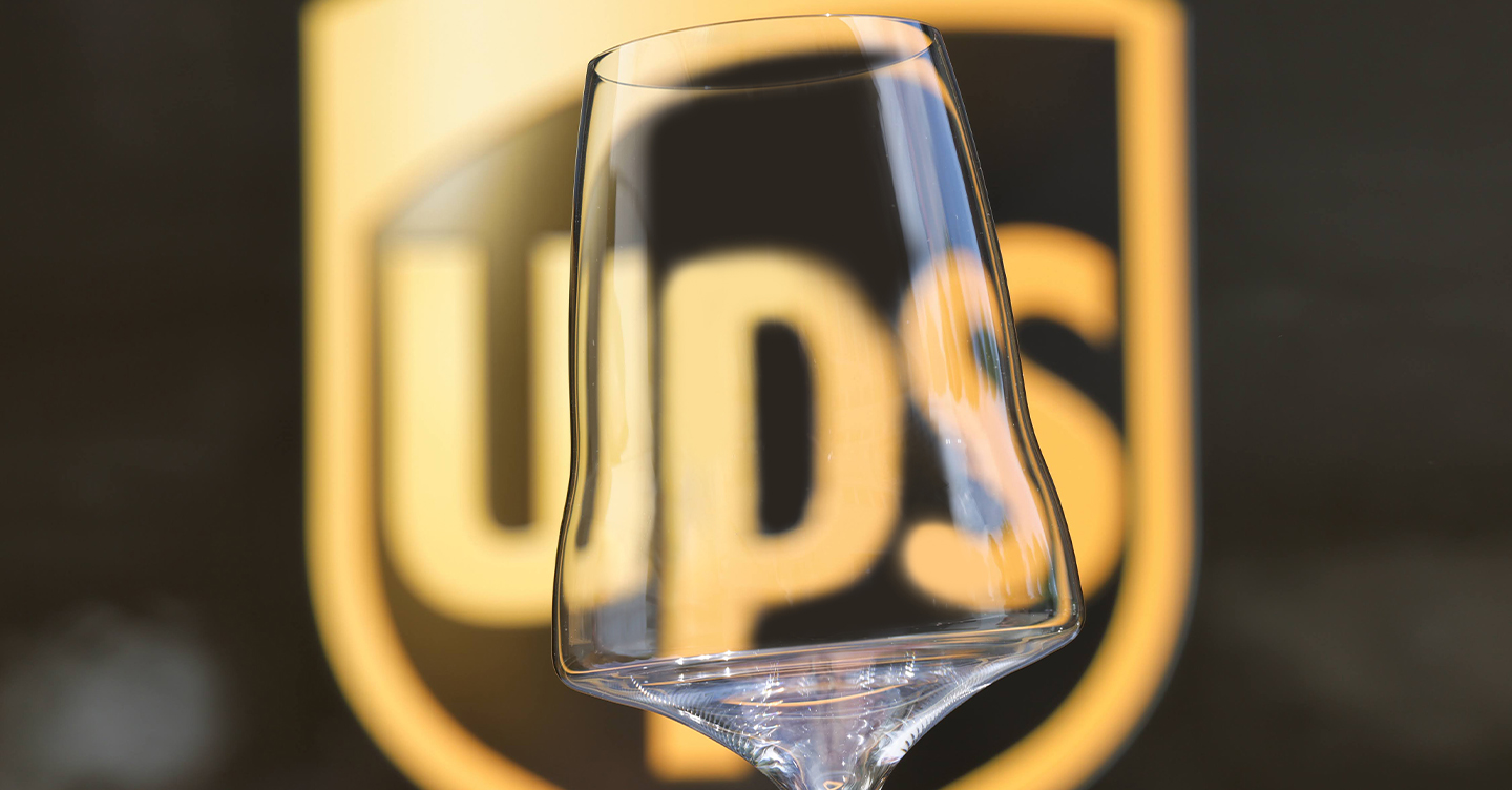 Una copa de vino Josephinenhütte brillante y de primera calidad con un logotipo visible de UPS detrás de su escritorio