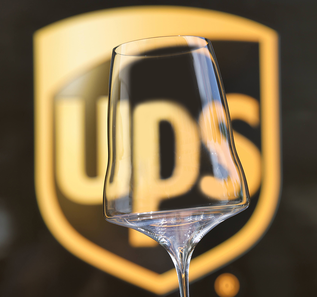 Una copa de vino Josephinenhütte brillante y de primera calidad con un logotipo visible de UPS detrás de ella móvil