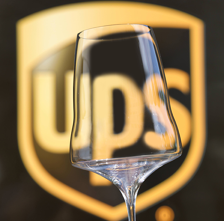 Una copa de vino Josephinenhütte brillante y de primera calidad con un logotipo visible de UPS detrás de su tableta