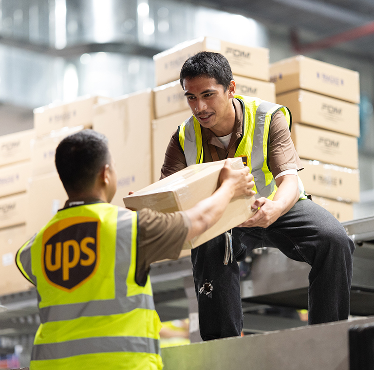 Warehouse workers handling UPS delivery boxes