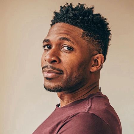 Man in maroon shirt with short curly hair