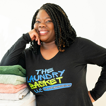 Woman with folded laundry wearing branded shirt