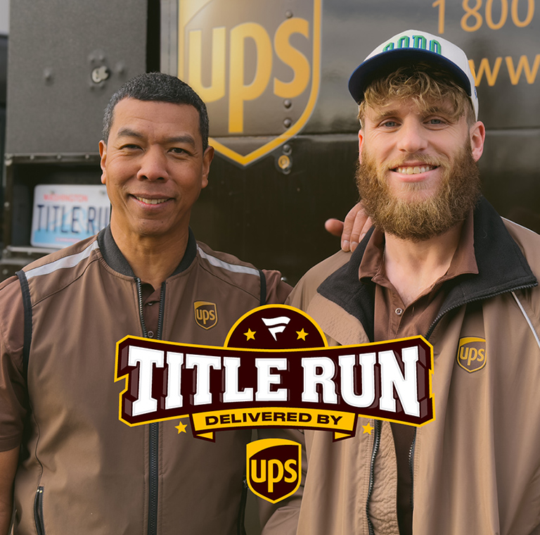 UPS driver and NFL player smiling at back of UPS vehicle