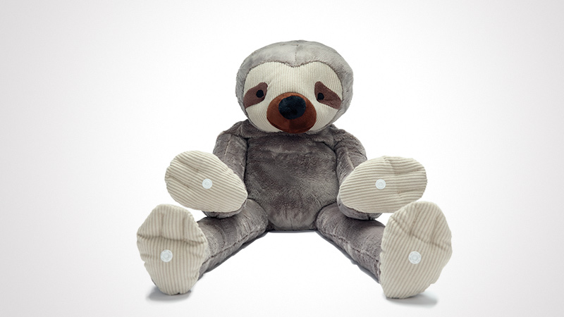 A cuddly plush sloth toy featuring soft gray and beige tones, seated against a plain white background. The toy has detailed facial features with a brown nose and striped beige fabric on its paws. Ideal for children or as a decorative item in a cozy setting.