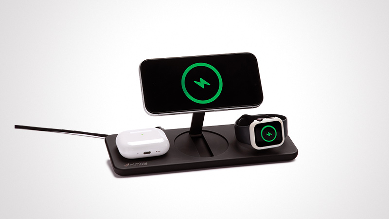 A sleek wireless charging station featuring a smartphone, earbuds, and smartwatch. The devices are displayed on a black charging dock with green charging icons visible on the screens. The setup is minimalistic and modern, emphasizing efficient charging for multiple gadgets.