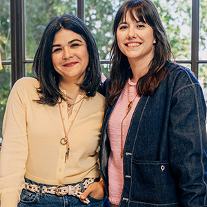 Two colleagues standing together by window