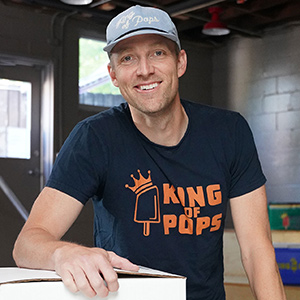 Man wearing King of Pops t-shirt indoors