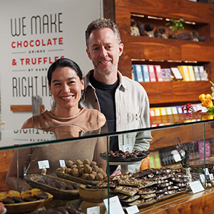 Artisan chocolatiers behind glass display counter