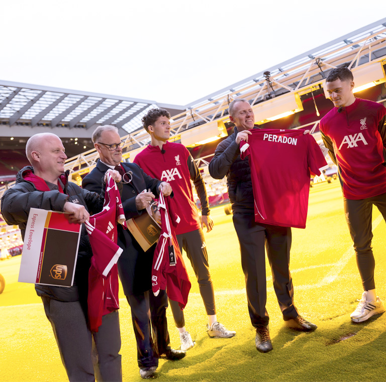 Group of men holding soccer jerseys