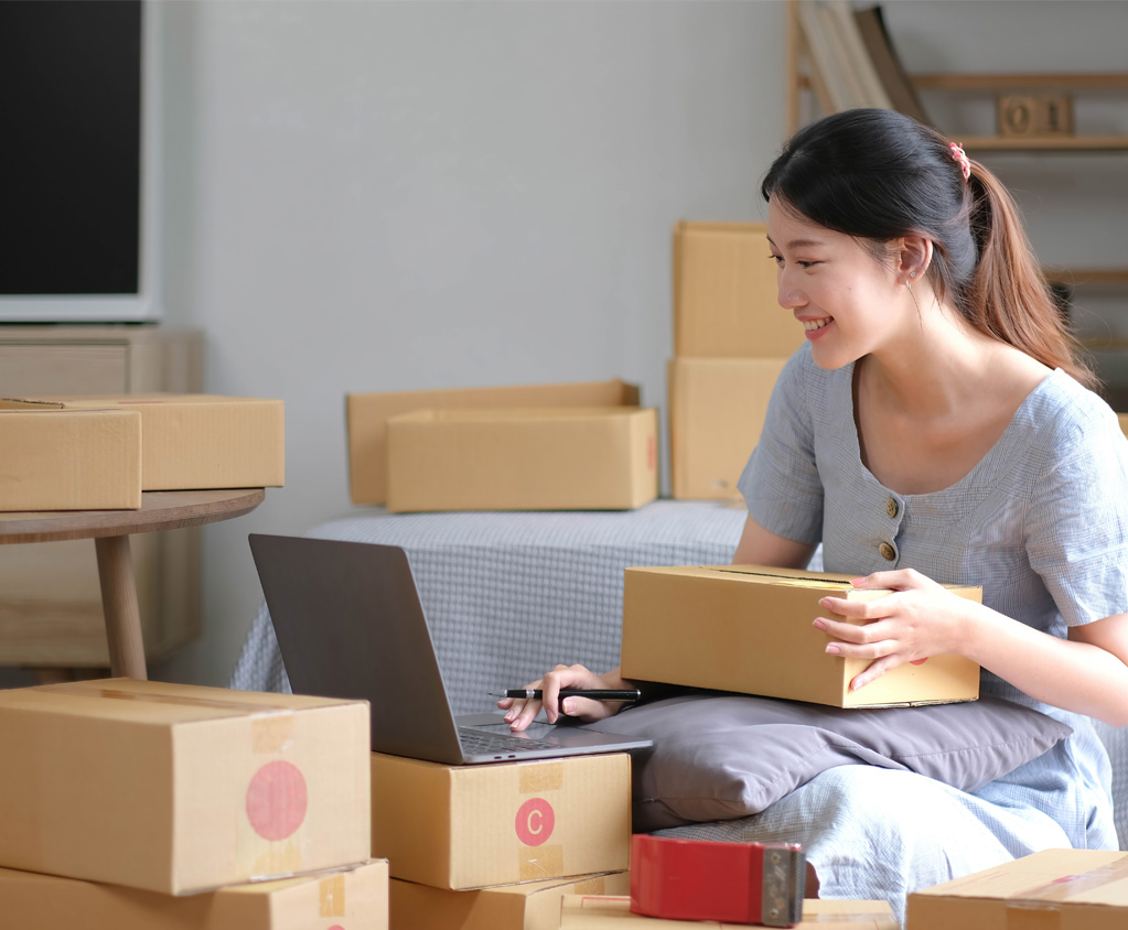 Mujer gestionando pedidos en línea con portátil