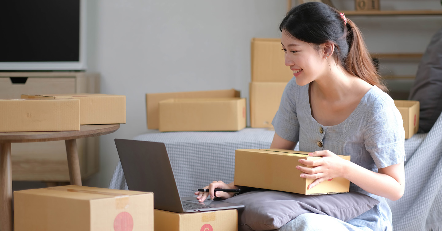 Mujer gestionando pedidos en línea con portátil