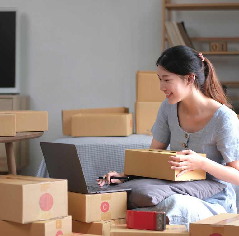 Mujer gestionando pedidos en línea con portátil