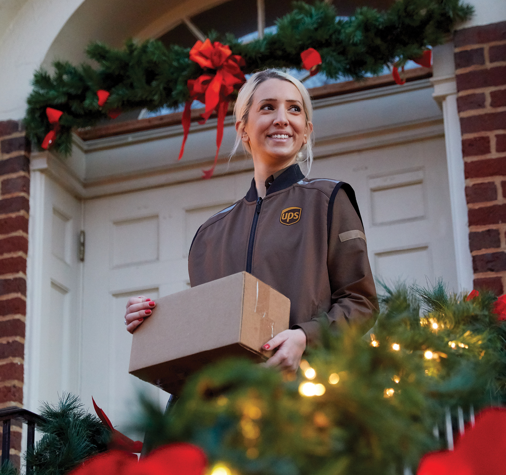 Personne chargée de la livraison tenant le colis pendant les fêtes