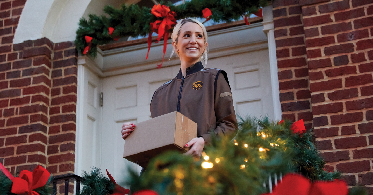Personne chargée de la livraison tenant le colis pendant les fêtes