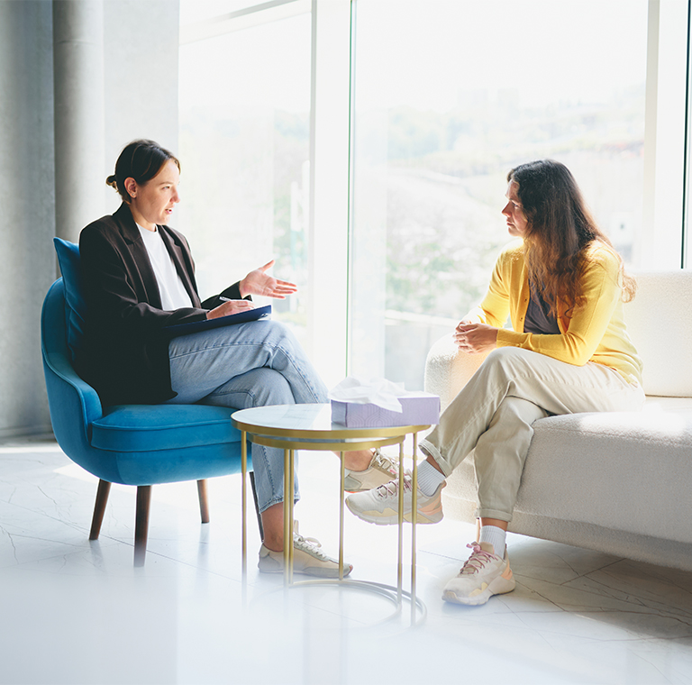 Two women talking in bright modern office