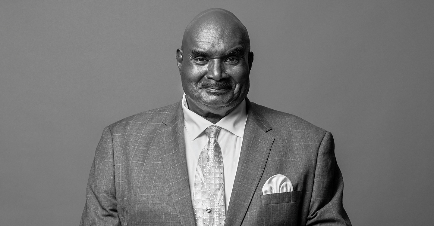 Black and white portrait of Cal Darden wearing a tailored suit and patterned tie