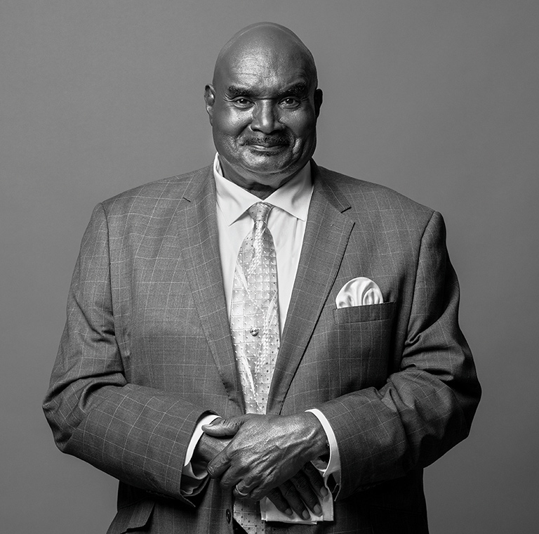 Black and white portrait of Cal Darden wearing a tailored suit and patterned tie