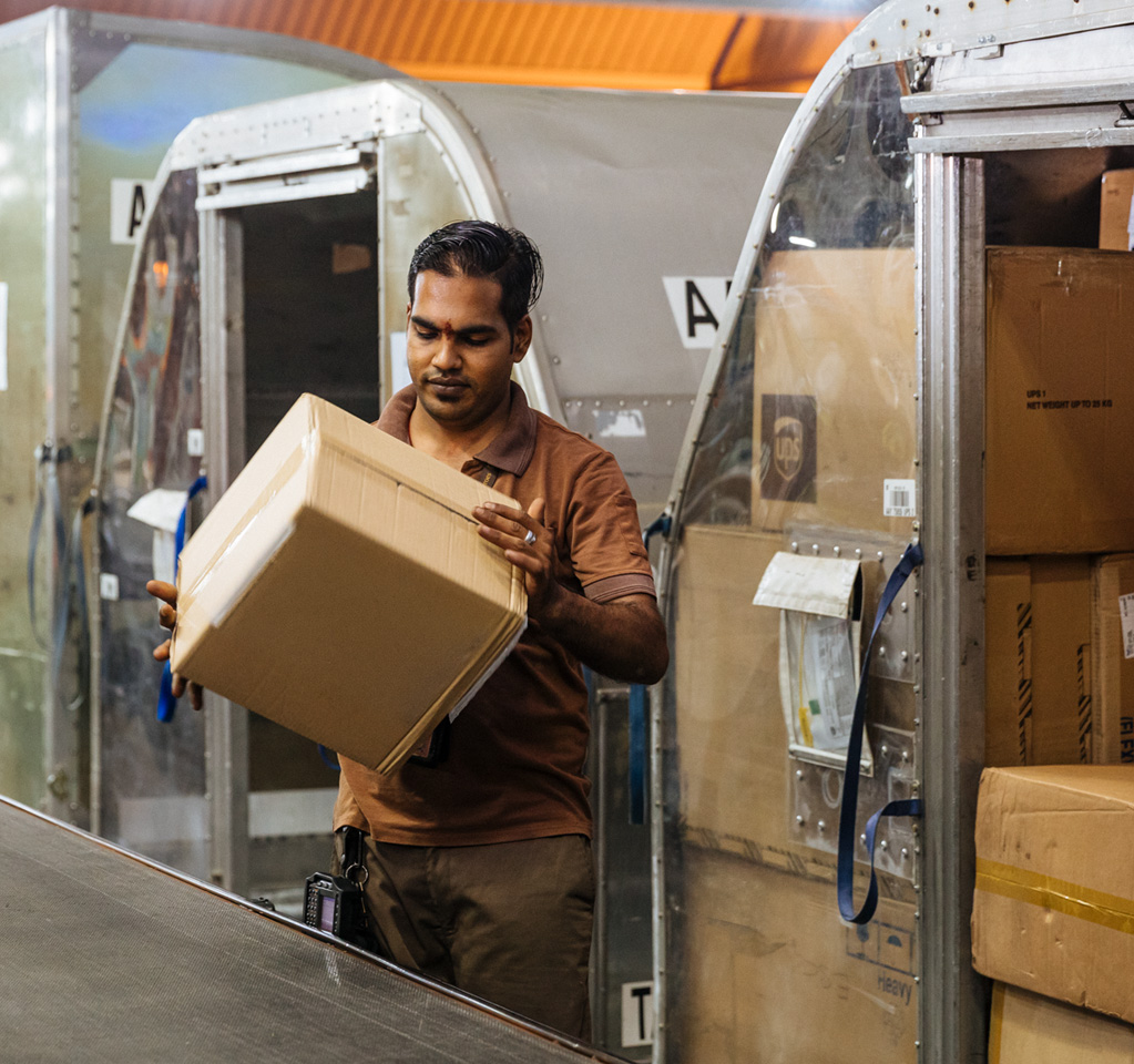Worker handling parcels in distribution facility