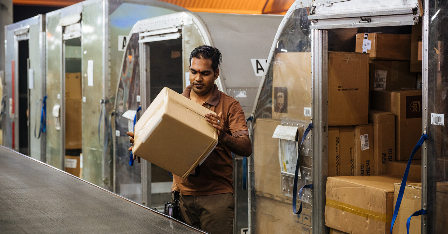Worker handling parcels in distribution facility