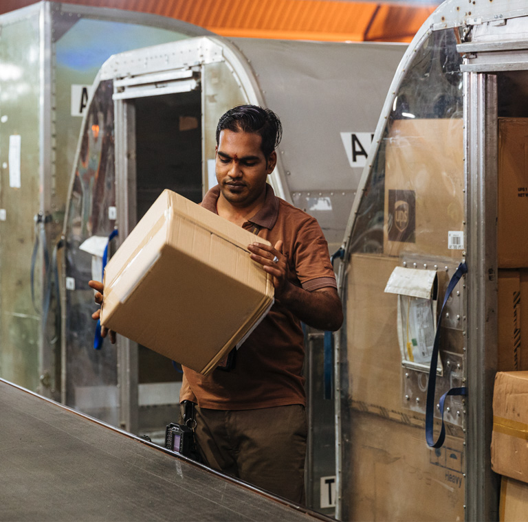 Worker handling parcels in distribution facility